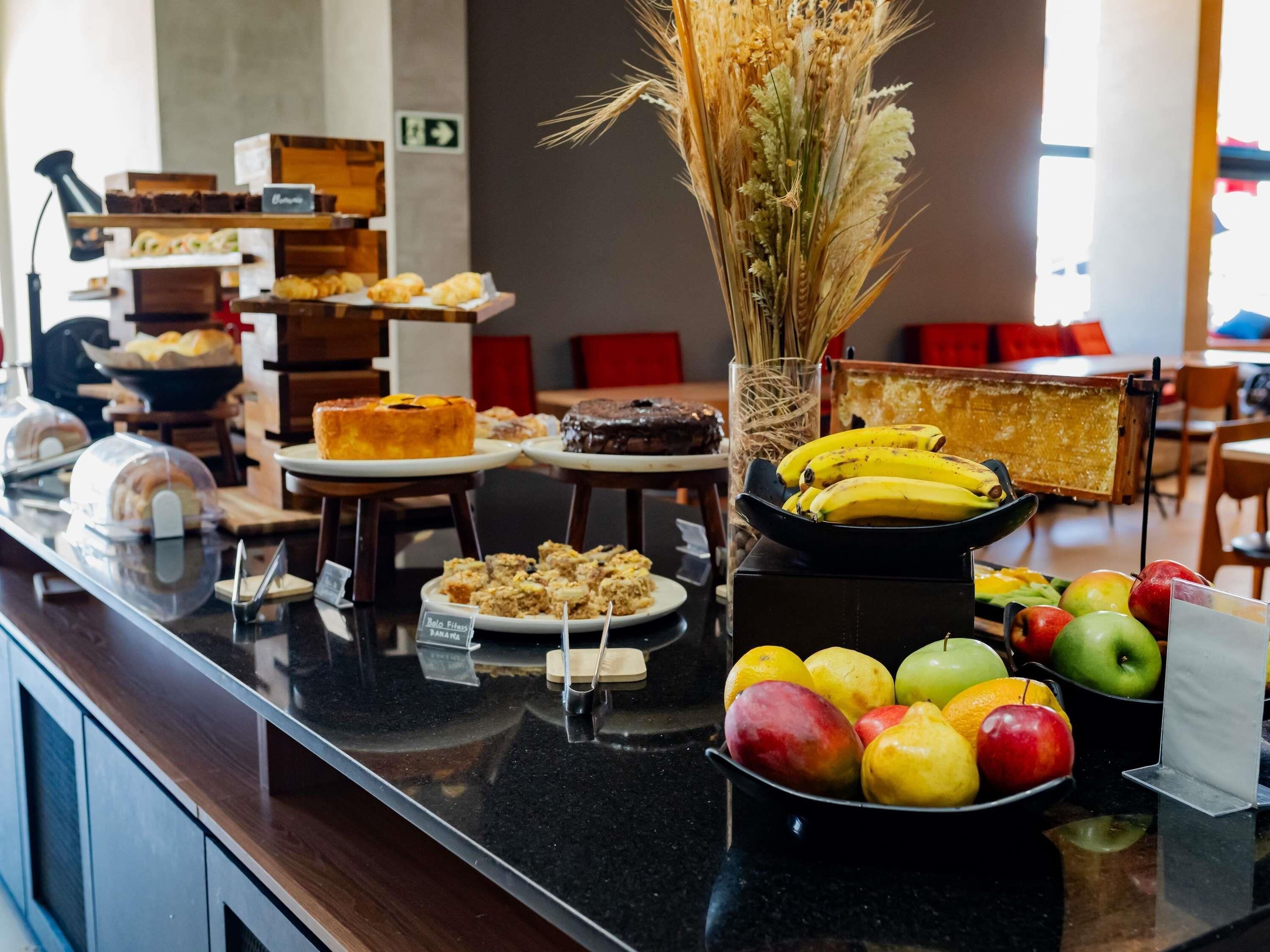 A buffet with various food items including pastries, cakes, and fruits.