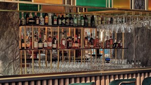 A bar area with multiple shelves of liquor bottles and a variety of glasses. - Mövenpick Grand Hotel Wroclaw (Wroclaw)