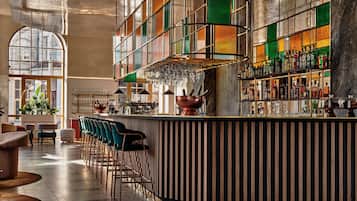 Un espace bar doté d’un comptoir incurvé, de tabourets de bar et d’une variété de bouteilles et de verres.