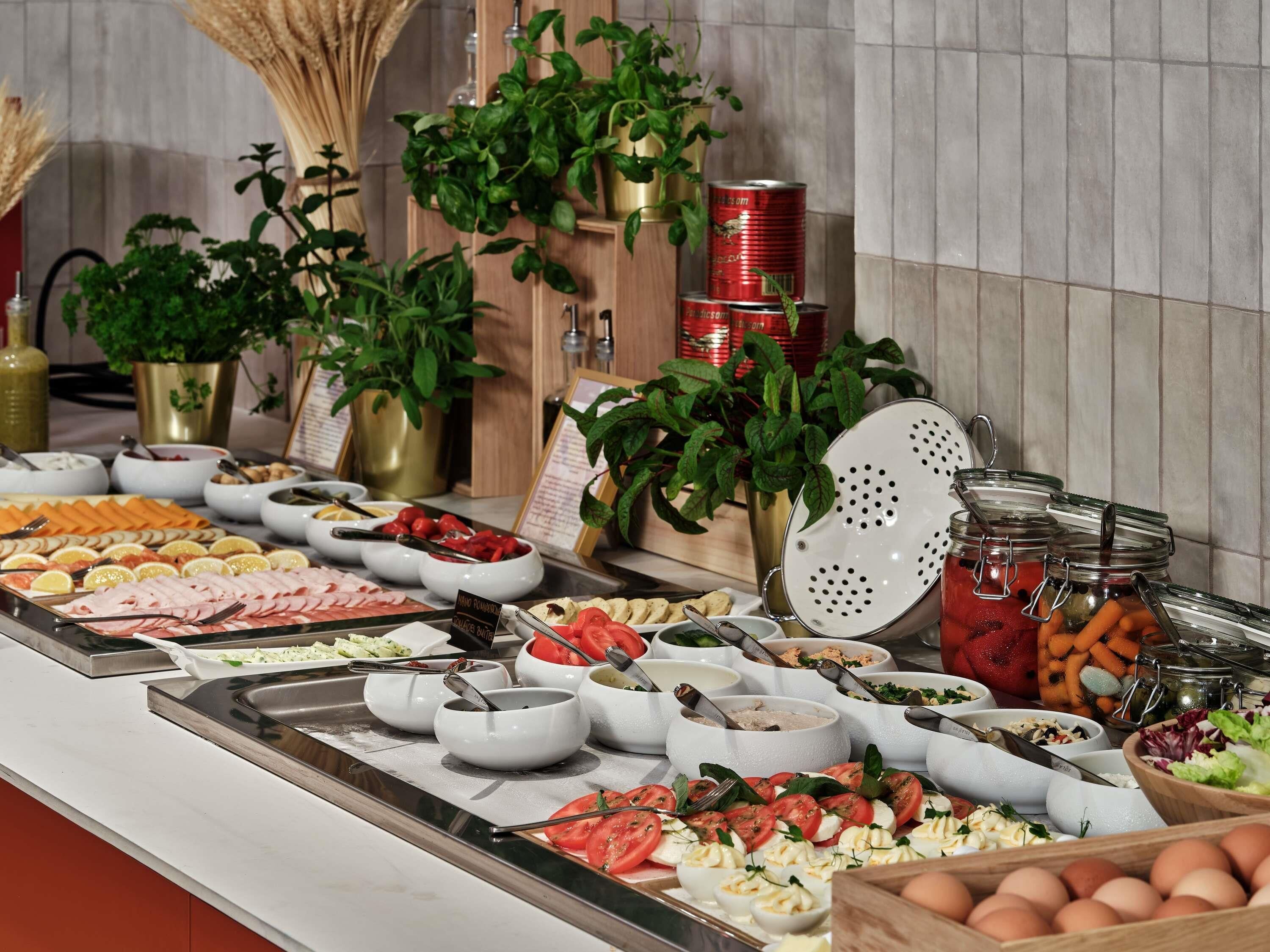 Ein reichhaltiges Buffet mit verschiedenen Speisen, darunter Fleisch, Käse und Gemüse.