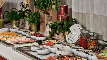 Ein reichhaltiges Buffet mit verschiedenen Speisen, darunter Fleisch, Käse und Gemüse.