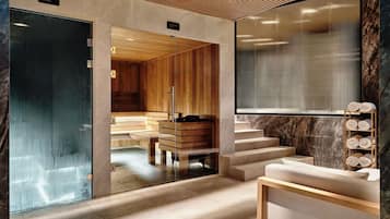 A modern spa area with wooden benches, a sauna, and a glass-walled relaxation room.