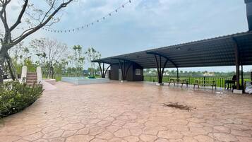 Relax in a serene outdoor setting surrounded by lush greenery and a charming stage.