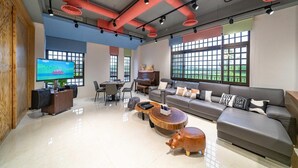 A spacious living area with a gray sofa, a wooden coffee table, and a television on a wooden cabinet. - Young Villa (Wujie)