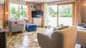 A cozy living room with a television, two sofas, a coffee table, and a fireplace. - 4 Person Holiday Home in Oksbol-by Traum (Oksbol)