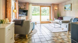 A cozy living room with a television, sofa, and a dining area. - 4 Person Holiday Home in Oksbol-by Traum (Oksbol)