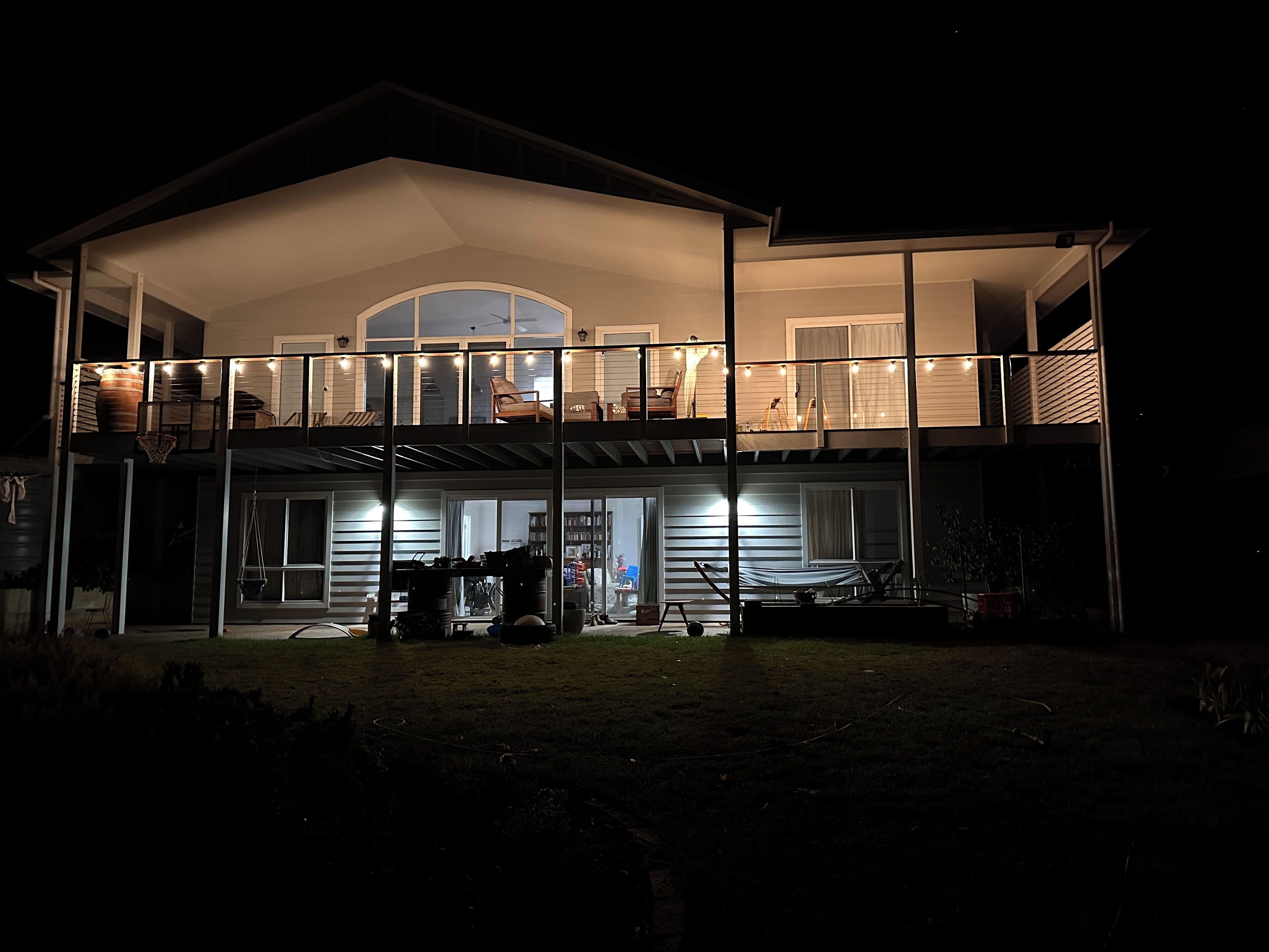A two-story house with a balcony, a covered porch, and a visible garage.