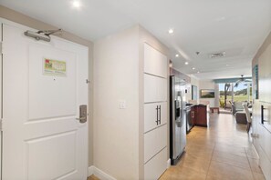 A modern kitchen with a refrigerator, cabinets, and a dining area with a view.