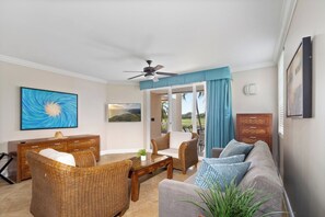 A living room with a ceiling fan, wicker furniture, a sofa, and a coffee table.