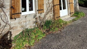 A stone house with wooden shutters, a small balcony, and a gravel driveway. - la Longere du Haut Courby en Plein Cœur de la Forêt Domaniale de Sédières (Eyrein)