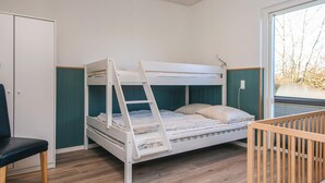 A bunk bed room with a desk and chair, a window with a view of trees, and a door. - 5 Star Holiday Home in Tarm (Tarm)
