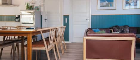A modern living space with a dining area, kitchen, and seating area.