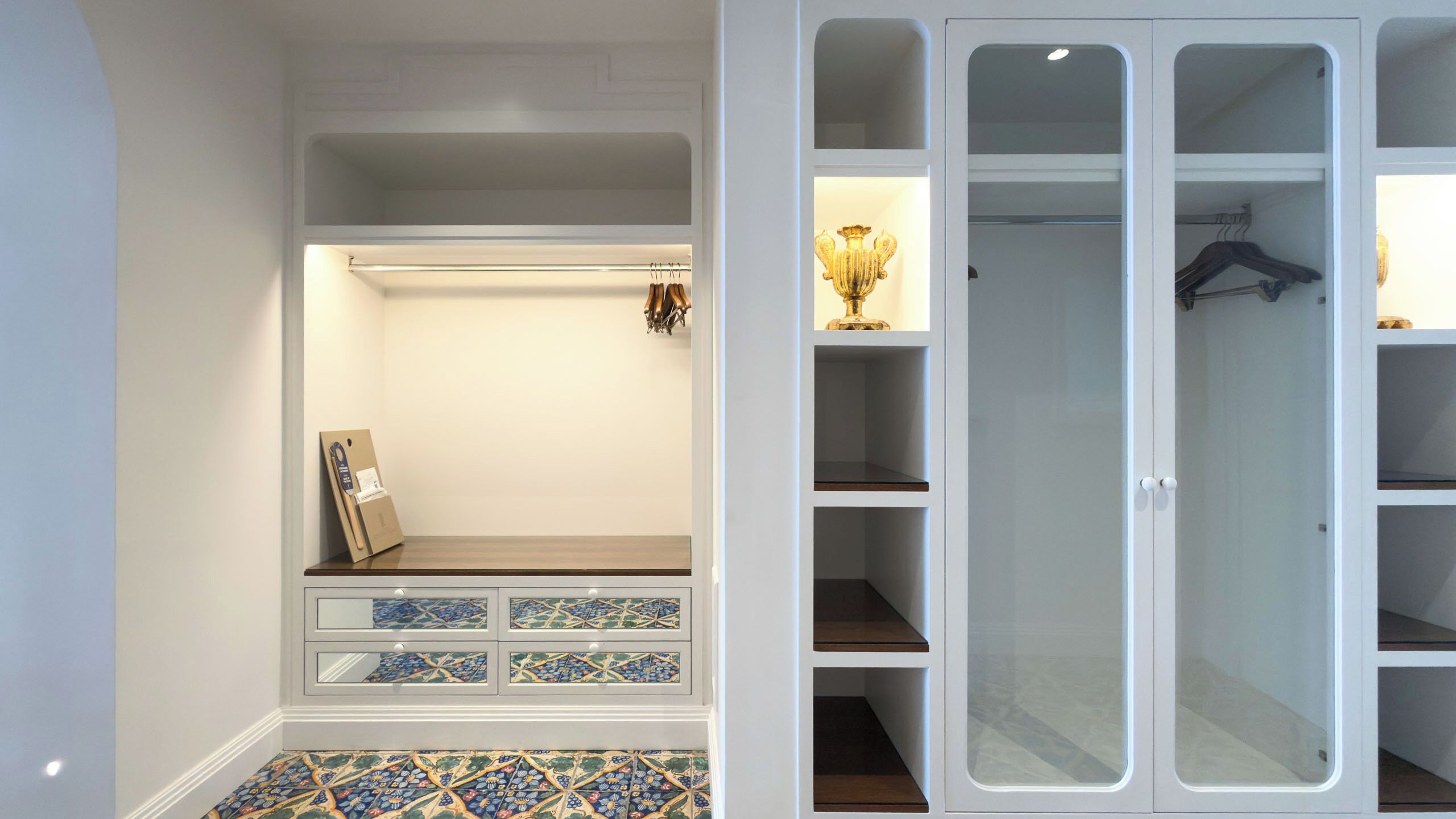 A walk-in closet with open shelves, a hanging rod, and a tiled floor.