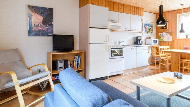 A compact living space with a kitchenette, a sofa, a television, and a dining area. - 4 Person Holiday Home in Fano (Fano)