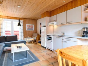 A compact living space with a kitchenette, a sofa, a dining table, and a rocking chair. - 4 Person Holiday Home in Fano (Fano)