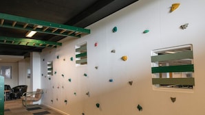 A climbing wall with various holds and a chair in the foreground. - 4 Star Holiday Home in Fano (Fano)