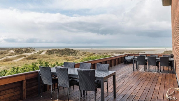 A wooden deck with outdoor seating overlooking a beach. - 4 Star Holiday Home in Fano (Fano)