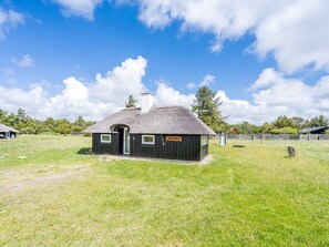 A small, single-story building with a thatched roof, a sign reading 'Strahallen,' and a fenced surrounding. - 4 Star Holiday Home in Vejers Strand (Vejers Strand)