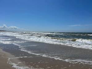 A beach with waves approaching the shore. - 6 Person Holiday Home in Hvide Sande (Hvide Sande)