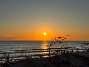 A sunset over the ocean with a sandy beach in the foreground. - 6 Person Holiday Home in Hvide Sande (Hvide Sande)