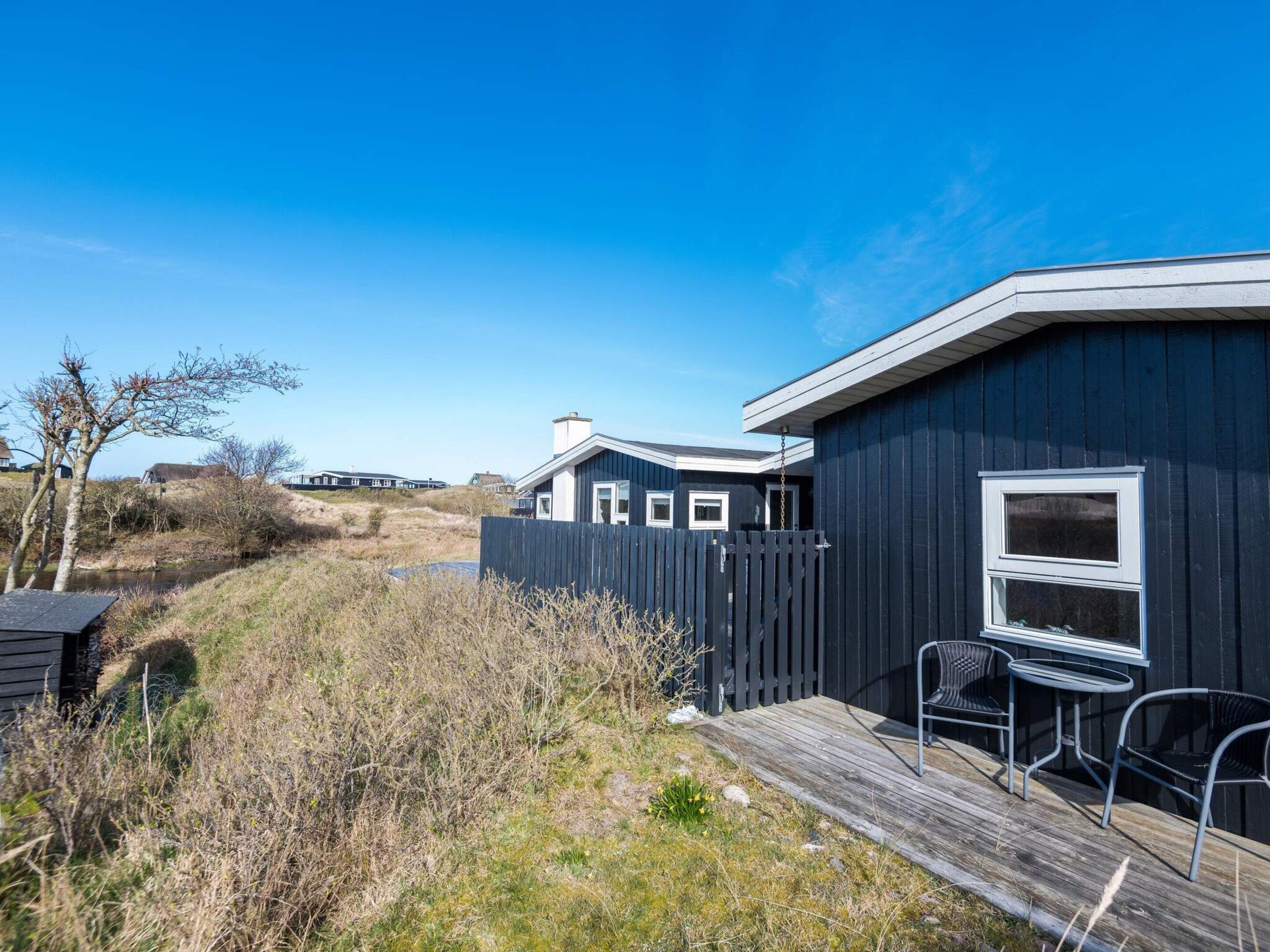 Een gelijkvloers huis met een terras, een klein zitgedeelte buiten en uitzicht op een waterpartij.