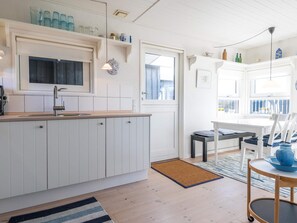 A modern kitchen with white cabinetry, a built-in oven, and a window above the sink. - 4 Person Holiday Home in Fano (Fano)