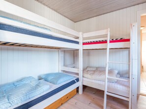 A bunk bed room with a wooden floor and white walls. - 4 Person Holiday Home in Fano (Fano)