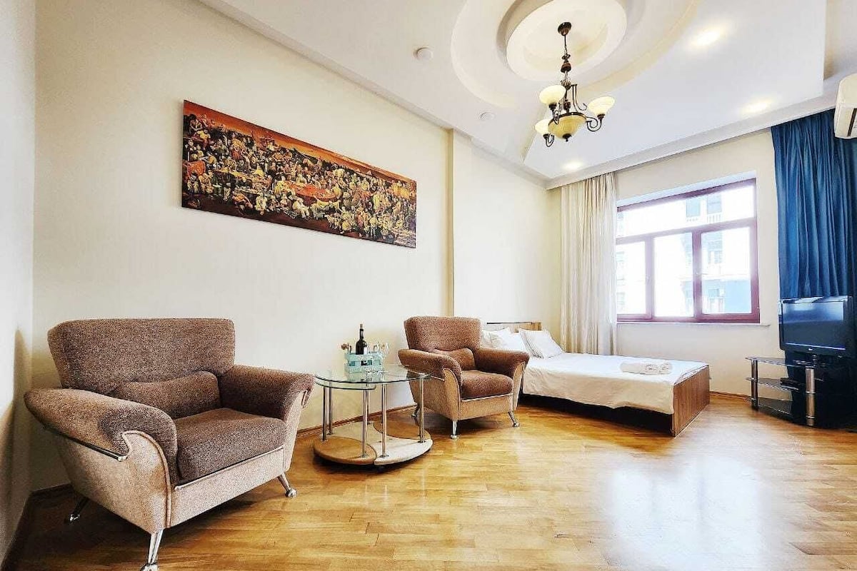 A living room with a sofa, armchair, and a small table with a tray.