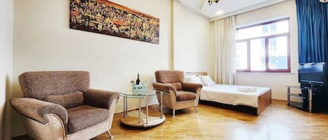 A living room with a sofa, armchair, and a small table with a tray.
