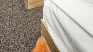 Ett hotellrum med två sängar, ett skrivbord och en stol.
