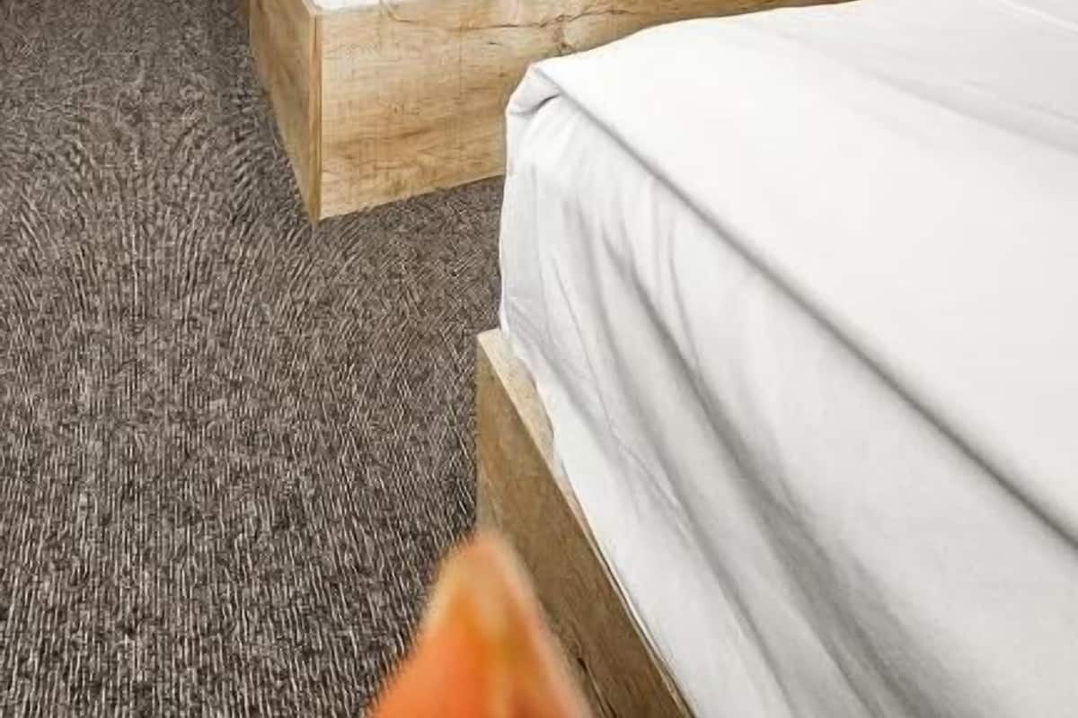 A hotel room with two beds, a desk, and a chair.