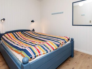 Un lit avec une couvre-lit à rayures, une tête de lit et un pied de lit.