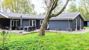 A modern house with a covered patio, a swing, and a garden. - 6 Person Holiday Home in Veslos (Vesløs)