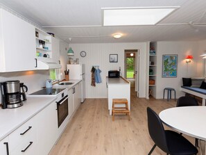 A compact kitchen with white cabinetry, a coffee maker, a microwave, and a sink. - 6 Person Holiday Home in Veslos (Vesløs)