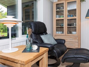 Un salon moderne avec un canapé en cuir, une table en bois et un meuble avec des portes en verre.