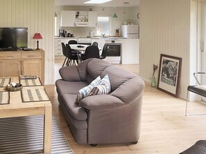 A living room with a sofa, a coffee table, and a television. - 6 Person Holiday Home in Veslos (Vesløs)