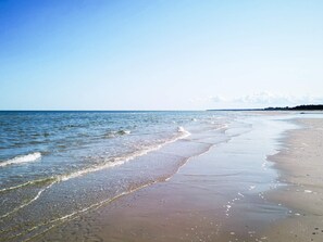 A beach with clear water, a sandy shore, and a distant shoreline. - 4 Star Holiday Home in Hadsund (Hadsund)