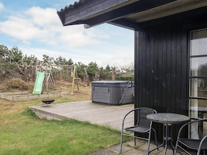 A patio with a hot tub, outdoor seating, and a slide. - 4 Star Holiday Home in Hadsund (Hadsund)