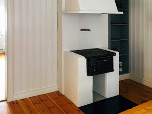 A compact kitchen with a built-in stove, white cabinetry, and a wooden floor. - 3 Person Holiday Home in Eskilstuna (Eskilstuna)