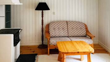 Una sala de estar con un sofá, una mesa de madera, una lámpara y una estufa.