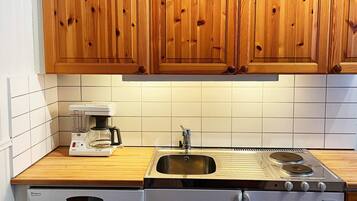 A kitchen with wooden cabinets, a Bosch coffee maker, a sink, and a Husqvarna stove.