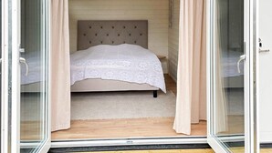 A bedroom with a bed, a headboard, a window, and curtains. - 4 Star Holiday Home in Farhult (Hoganas)