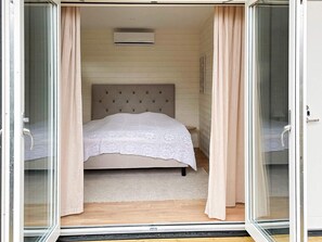 A bedroom with a bed, a headboard, a window, and curtains. - 4 Star Holiday Home in Farhult (Hoganas)