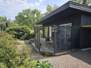 A modern building with a covered patio area, surrounded by dense greenery. - 4 Star Holiday Home in Farhult (Hoganas)