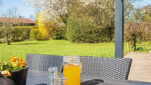 An outdoor seating area with a table, chairs, and a drink. - 6 Person Holiday Home in Sydals-by Traum (Sydals)