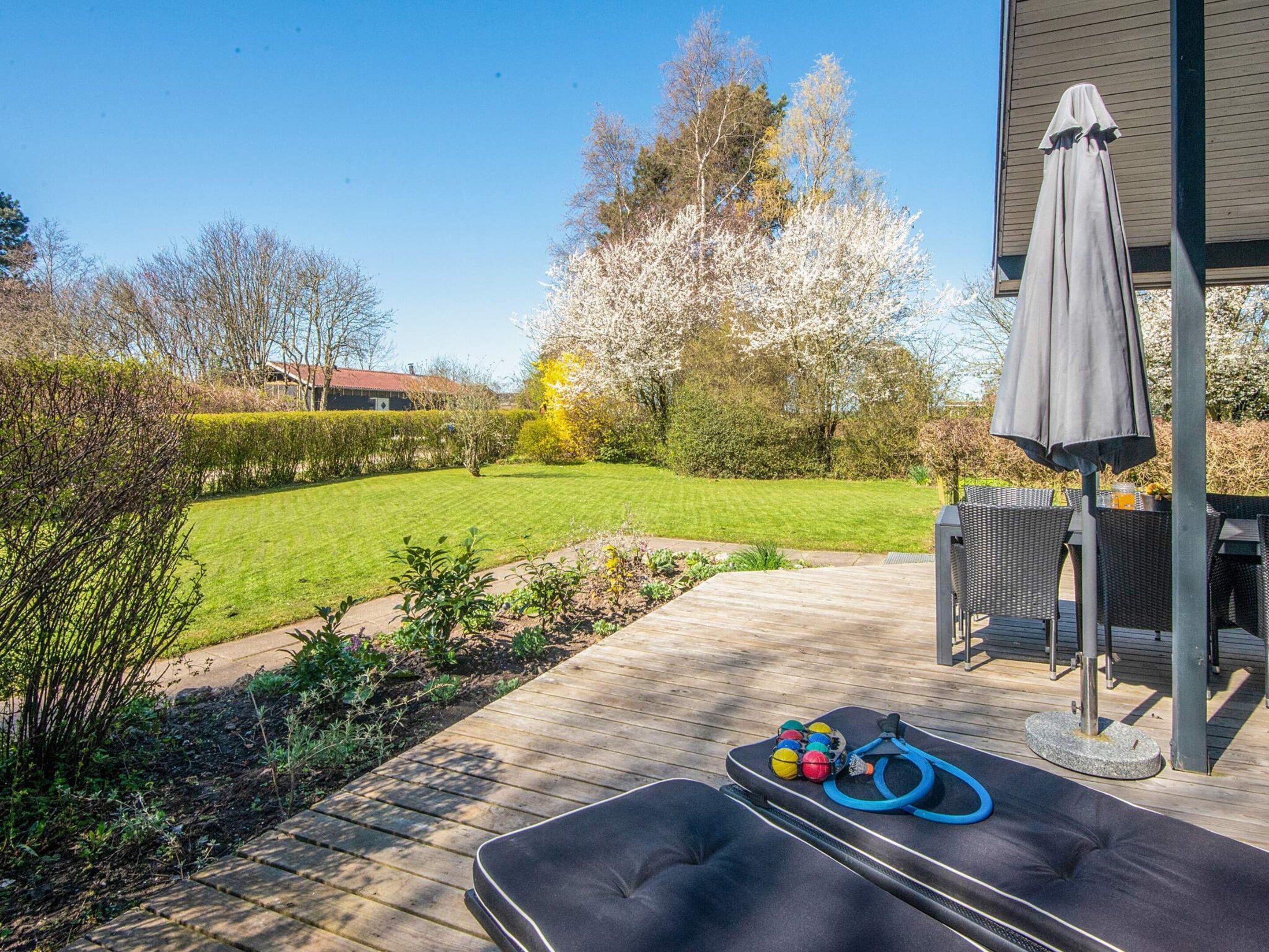 Une terrasse avec des meubles d’extérieur, une table de billard et du matériel d’exercice.