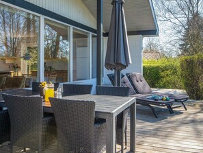 An outdoor deck with wicker furniture, a table with a drink, and a lounge area with cushions. - 6 Person Holiday Home in Sydals-by Traum (Sydals)
