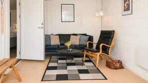 A room with a sofa, a chair, a coffee table, a rug, and a door leading to another room. - 6 Person Holiday Home in Sydals-by Traum (Sydals)