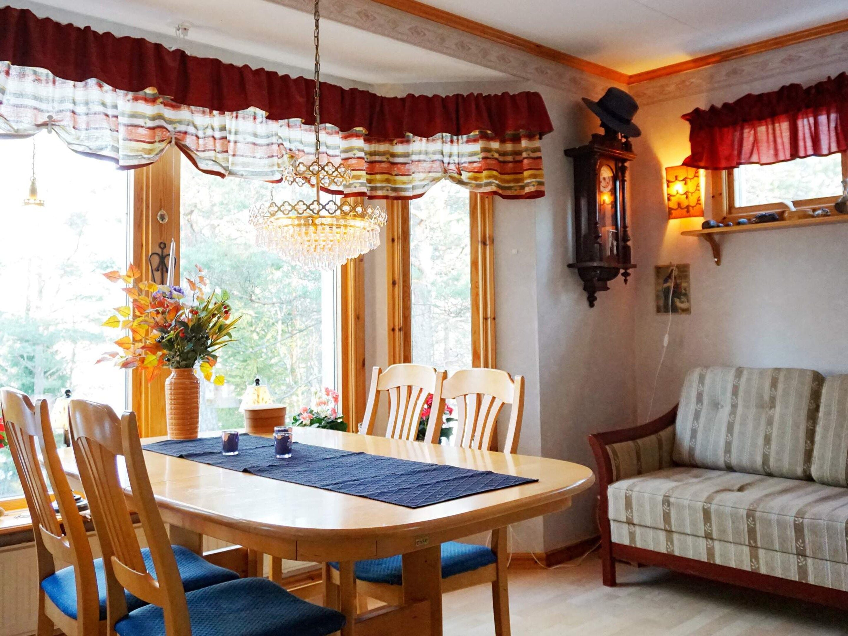 Uma sala de jantar com uma mesa de madeira, cadeiras e um lustre.