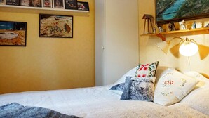 A bedroom with a bed, pillows, a lamp, a shelf with figurines, and framed pictures on the wall. - 4 Star Holiday Home in Bullaren (Bullaren)